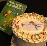 Jason Platt's book 'Middle School Misadventures' next to a cake with the cover of his book on the cake top