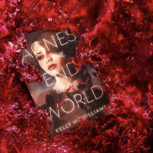 Picture of 'Agnes at the End of the World' sitting in a pile of red tinsel